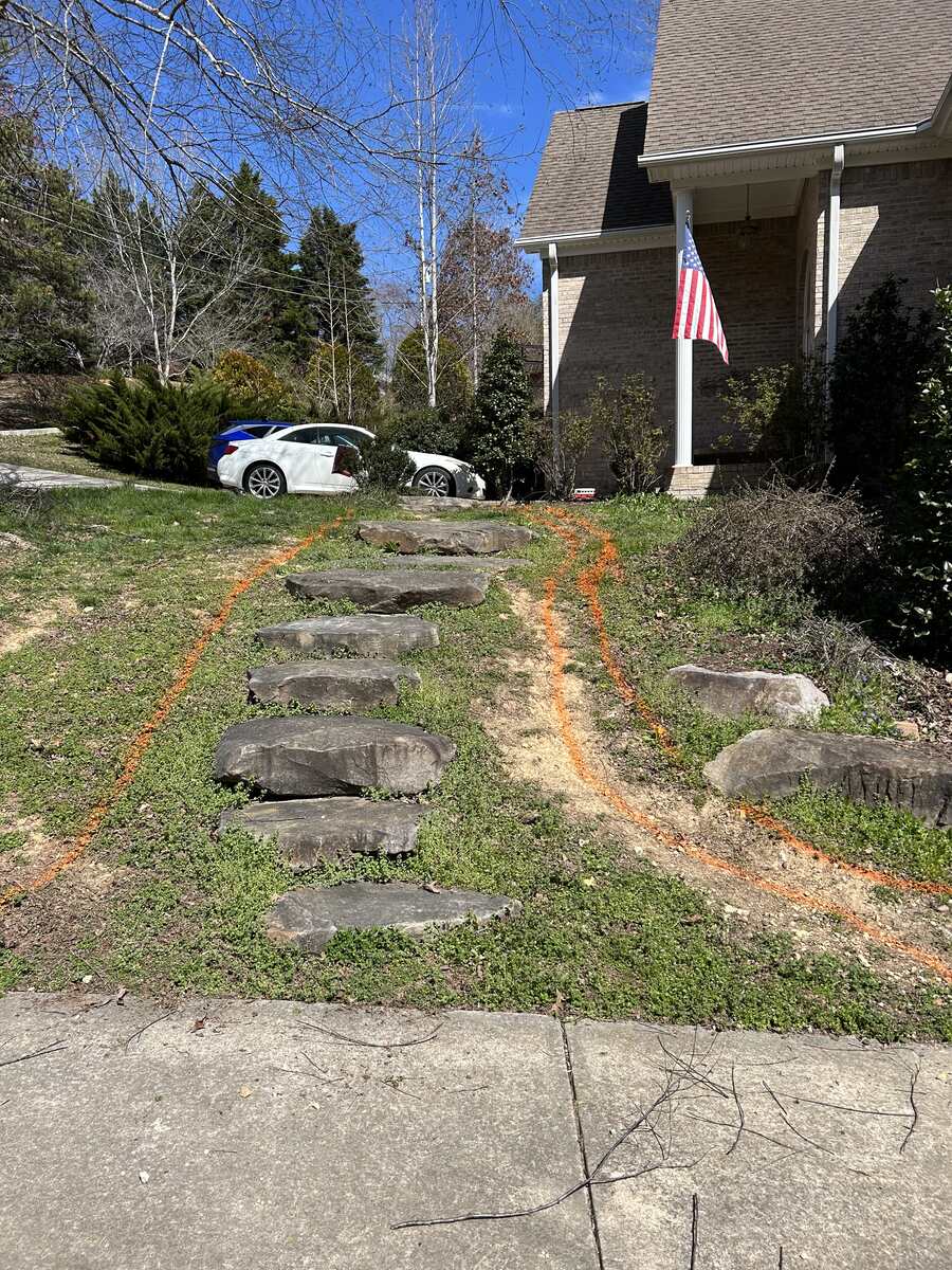Weedy, marked-out hillside with loose stone slabs before the path was built