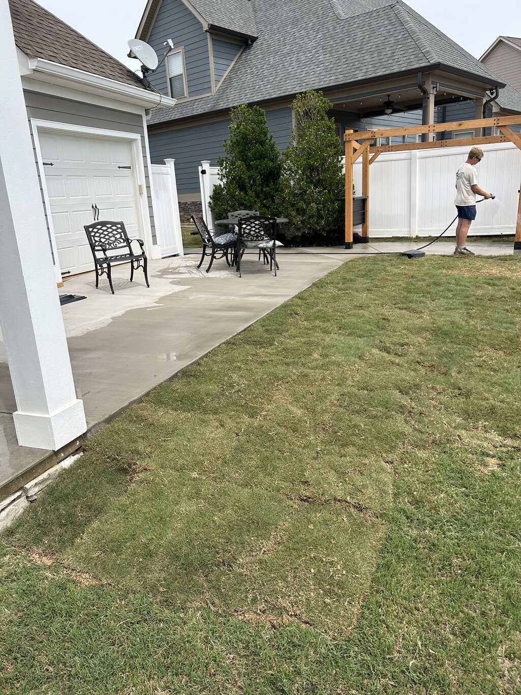 Fresh sod laid over a newly graded backyard slope