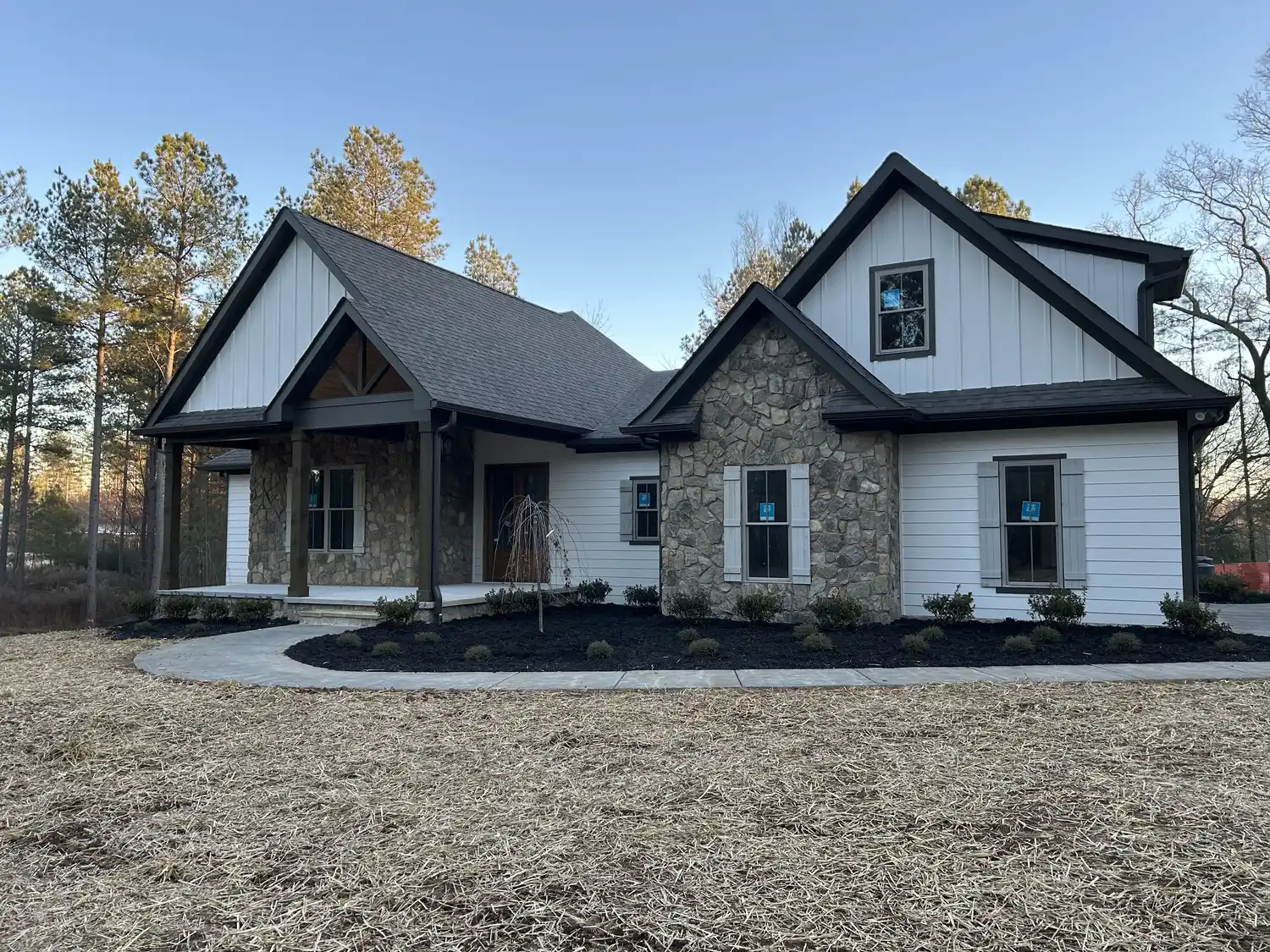 Clean craftsman home with fresh black mulch beds and tidy landscaping